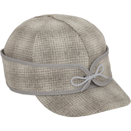 A 45 degree angle view of The Ida Kromer Cap: a wool, six-panel winter cap with a pulldown earband that ties in front and has a brim.