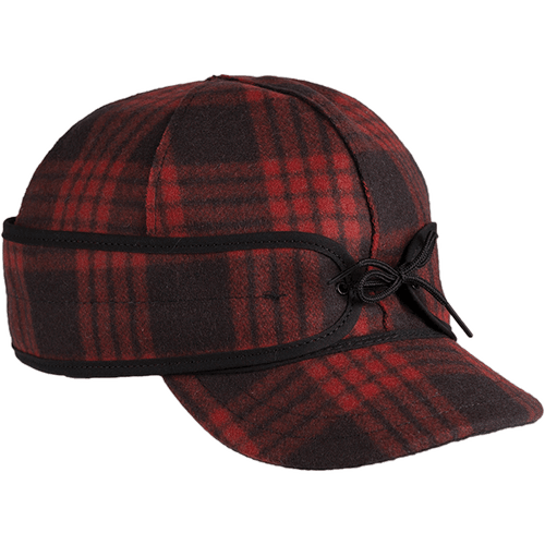 A 45 degree angle view of The Millie Kromer Cap: a wool, six-panel winter cap with a pulldown earband that ties in front, and a brim. 