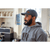 Photo of a man standing in a bright, white kitchen wearing a charcoal Waxed Cotton Curveball Cap and a gray hoodie.