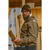 Man in a woodshop wearing an olive wool military beanie and tan hoodie