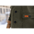 Close up detail of a leather Stormy Kromer logo patch sewn on to one of the front pockets.