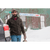 Photo of a man leaving a curling rink on a very snowy day, carrying a bag and wearing a brown waxed cotton Stormy Kromer Cap and an evergreen Boundary Jacket.