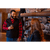 Photo of a man and woman holding glasses of wine in front of a stone fireplace. Man is wearing a red/black plaid flannel shirt and black Button Vest. Woman is wearing a green plaid vest.