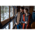 Man and woman standing together looking out large windows onto a snowy scene. Man is wearing a sand Waxed Button Vest and gray shirt; woman is wearing a rust long vest and gray shirt.