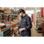 Photo of a man in an old-fashioned hardware store, pulling out a drawer of screws. Man is wearing a charcoal Stormy Kromer Rancher cap and a Storm Plaid Wool Shirt.