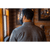 Photo of man from the back wearing The Wool Shirt in Slate and standing in a wood-paneled room. Back of shirt shows Stormy Kromer signature.