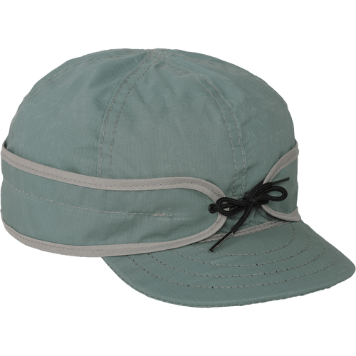 Side view of the Trail Cap - a six-paneled cap with an earband that ties in front and a brim, made with a lightweight waxed cotton.