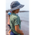 Image from the side of a young boy looking out at the water in a green shirt and wearing a charcoal Forager Hat.