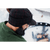 View from the side back of a man with a beard wearing a Stormy Kromer Midway cap with the earband pulled down to cover their ears.