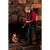 Image of a man in his 20s in front of a large fireplace, stoking the fire. He is wearing a red long sleeve shirt with the Indigo Boundary Vest.