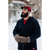 Image of a bearded man in his 30s standing in the snow in front of a bridge wearing a navy Stormy Kromer Tailgate Pullover and a red/black plaid wool Stormy Kromer cap.