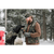 Image of a bearded man standing at the back of his pick up truck, petting his black Labrador retriever. The man is wearing a camouflage Stormy Kromer cap and vest; the dog is also wearing a Stormy Kromer camouflage jacket.
