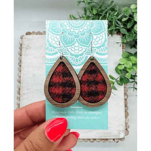 Pair of tear-drop shaped earrings made of a dark wood framing red and black wool fabric