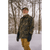 Gray bearded man wearing a waxed camo Squall Coat outside in the snow.