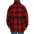 Classic wool button up coat with an extra layer of fabric over the top body and arms in red/black plaid on a man with a beard, back view